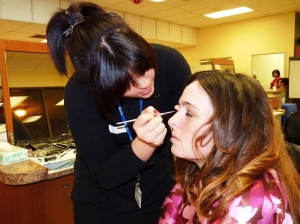 Student makeup artist Paloma Herber shows ECM writer Mary Paulet tips for applying eyeshadow.