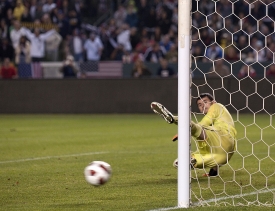 Chile goalkeeper Paulo Garces watches helplessly as the penalty kick shot struck by U.S. player Teal Bunbury heads into the goal.